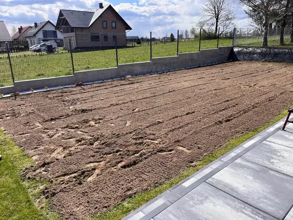 Teren pod trawnik po uprawie, obok chodnika z płyt