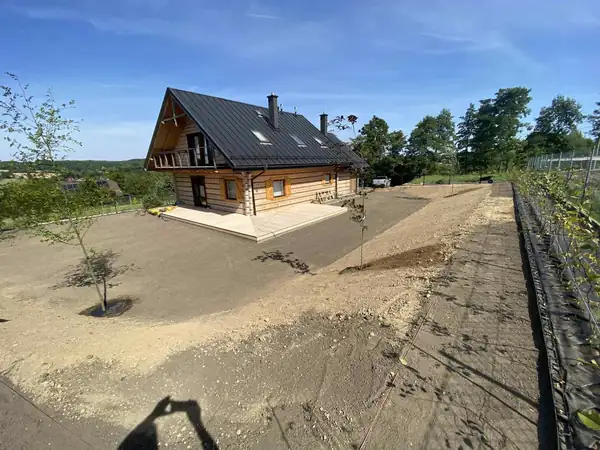 Wyrównany teren pod trawnik wokół drewnianego domu